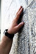 tastende Hände auf eines mosaikbezierten &quot;Teppichs&quot;