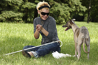 Bildtext: Blinde Frau mit Hund.
