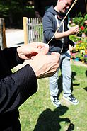 Bildtext: Hände bestasten Lein (Flachs), aus dem unter anderem Gewebe für die Gewandherstellung verwendet wird
