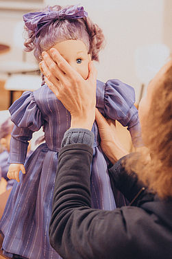 Eine Dame betastet eine Puppe.