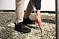 Bildtext: beide Beine stehen auf einem Beet aus Flusssteinen, die in der Region durch die Bäche und Flüsse angespült werden