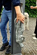 Skulptur von Martin Schnur. Hände ertasten eine der vier Figuren, die an einem riesigen einem Bilderrahmen ähnlichen Skulptur